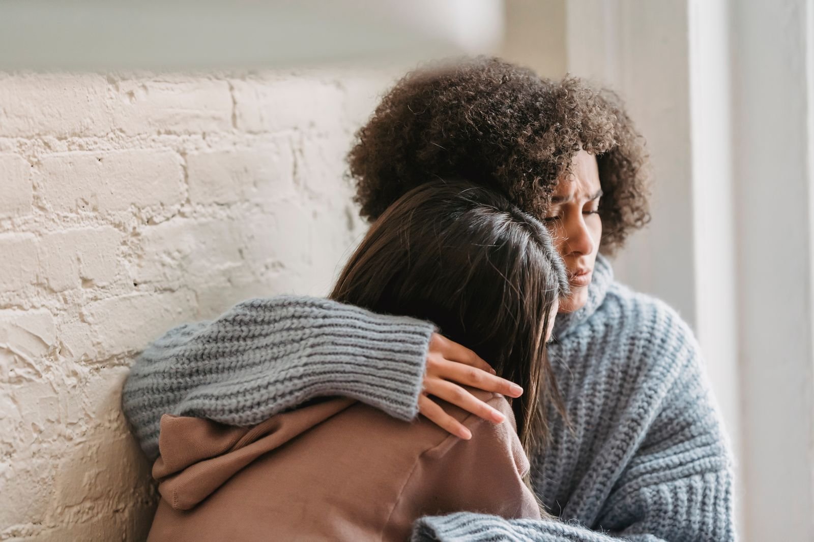 Two women hugging at home